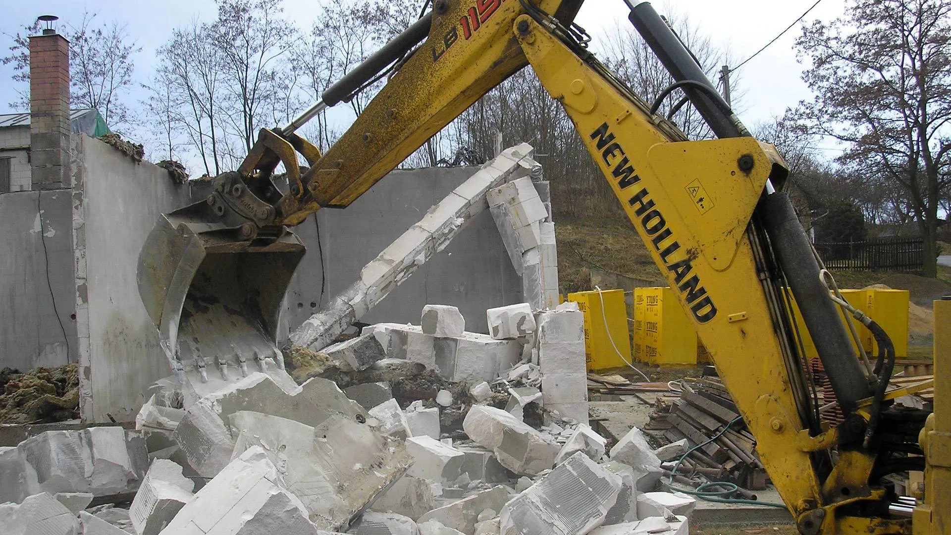 Strojní demolice objektu bagrem