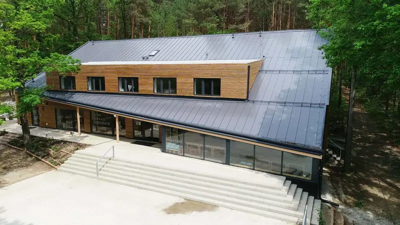 Letecký pohled na budovu s plechovou střechou v lese