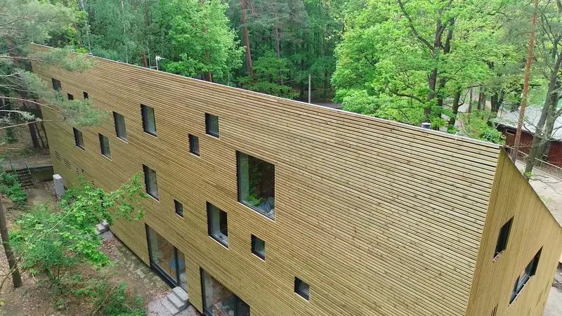 Dřevěná fasáda budovy obklopená zelení